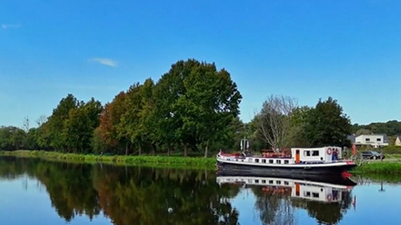 French Hotel Barge Nymphea moored in a pretty spot in Brittany, France